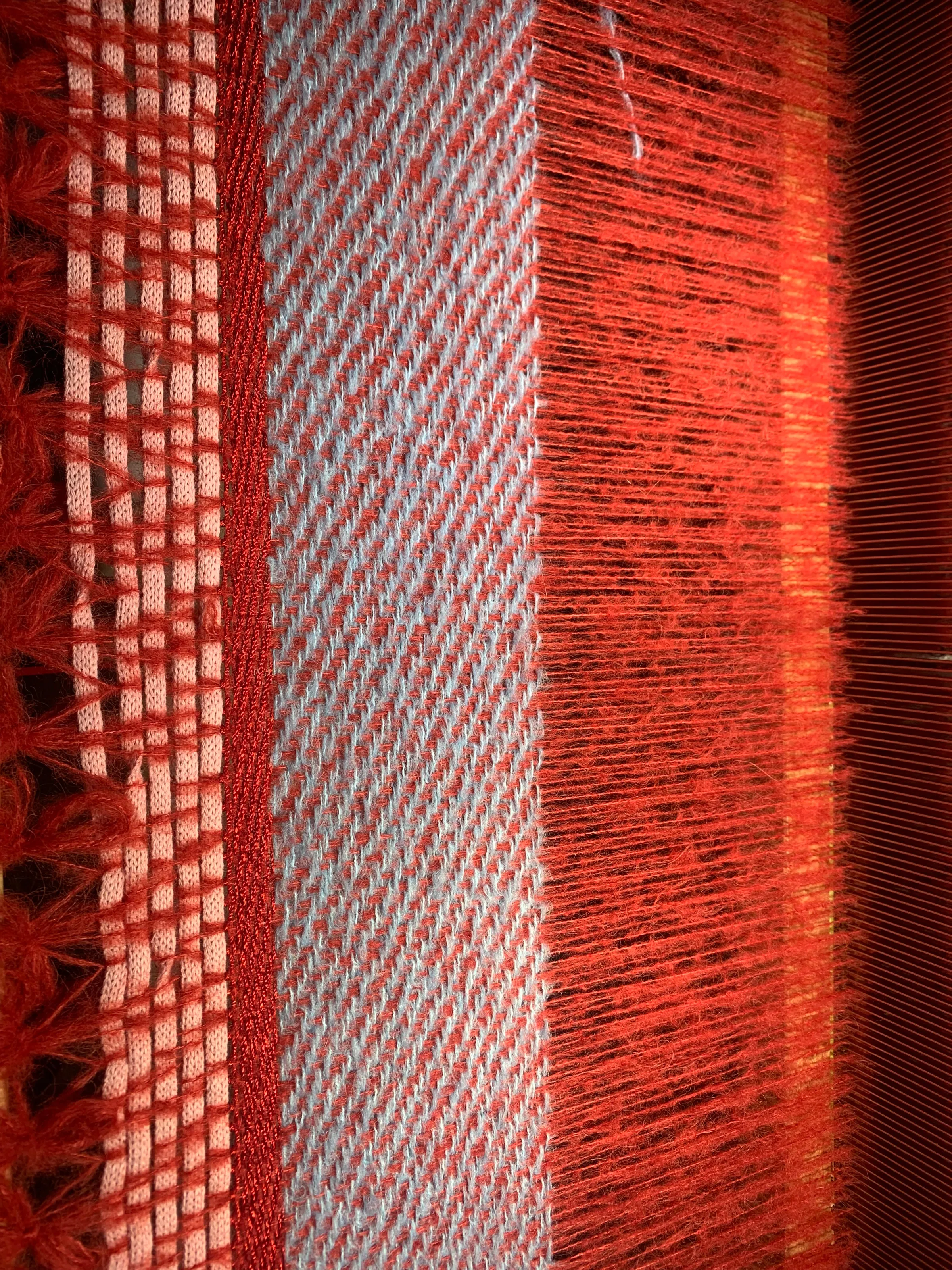 Départ de tissage : chaîne mohair rouge brique, bande de sergé bleu ciel, galon rouge et ruban rose entrecroisés